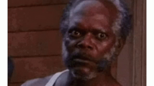 A Man With A Beard Is Making A Funny Face While Standing In Front Of A Building . GIF