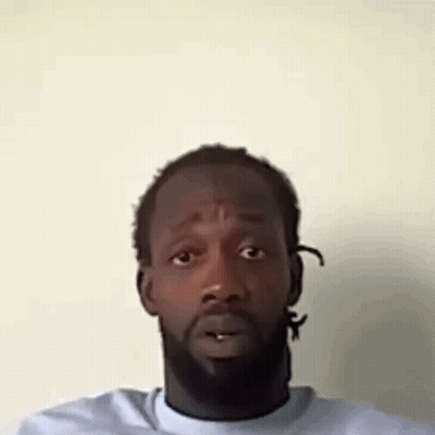 A Man With A Beard Is Making A Funny Face With His Mouth Open . GIF