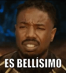 A Man With A Beard Is Making A Funny Face With The Words `` Es Bellissimo '' Written On It . GIF
