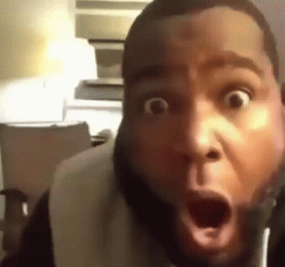 A Man With A Beard Is Making A Surprised Face With His Mouth Open . GIF