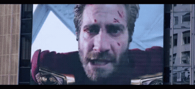 A Man With A Beard Is On A Large Screen GIF