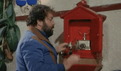 A Man With A Beard Is Opening A Red Mailbox With A Screwdriver . GIF