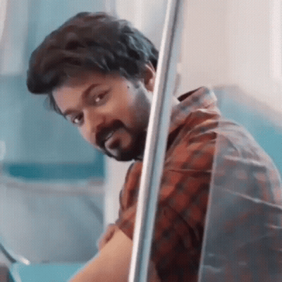 A Man With A Beard Is Peeking Out Of A Window And Looking At The Camera . GIF