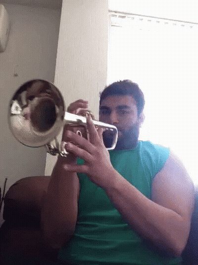 A Man With A Beard Is Playing A Trumpet GIF
