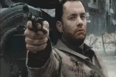 A Man With A Beard Is Pointing A Gun At Something . GIF