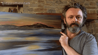 A Man With A Beard Is Pointing At A Painting That Says Itsscottiesstark On It GIF