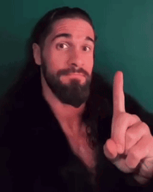 A Man With A Beard Is Pointing His Finger Up . GIF