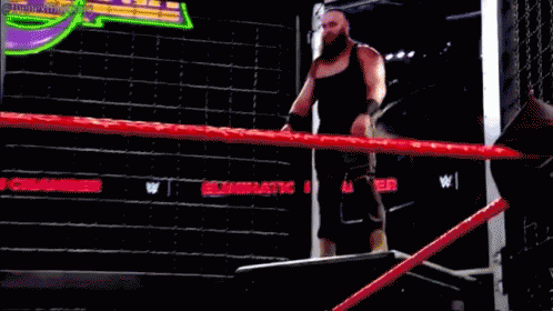 A Man With A Beard Is Raising His Fist In The Air While Wearing A Black Tank Top GIF