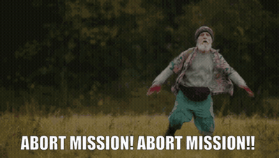 A Man With A Beard Is Running In A Field With The Words Abort Mission Behind Him GIF