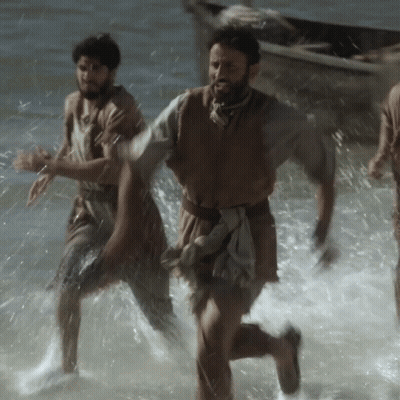 A Man With A Beard Is Running Through The Water GIF