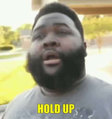 A Man With A Beard Is Saying Hold Up In Yellow Letters GIF