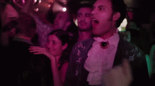 A Man With A Beard Is Screaming At Another Man GIF