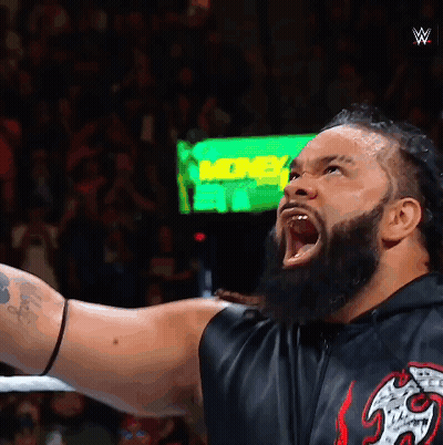 A Man With A Beard Is Screaming In Front Of A Green Sign That Says ' More ' GIF