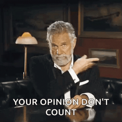 A Man With A Beard Is Sitting At A Table With His Hands In The Air And The Words Your Opinion Do N't Count GIF