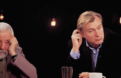 A Man With A Beard Is Sitting At A Table With His Head In His Hands GIF