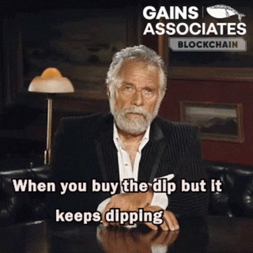 A Man With A Beard Is Sitting At A Table With The Words Gains Associates Blockchain Written On The Bottom GIF