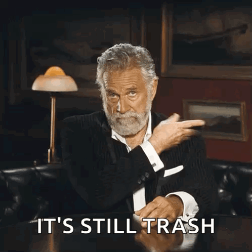 A Man With A Beard Is Sitting At A Table With The Words It 'S Still Trash Written On It GIF
