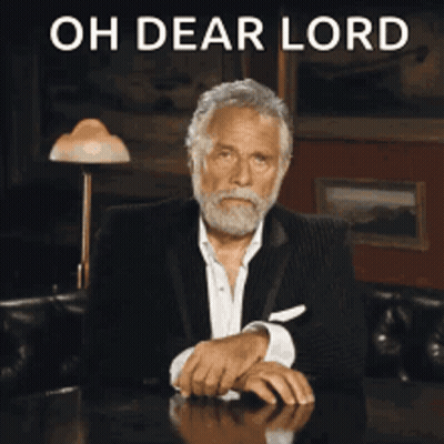A Man With A Beard Is Sitting At A Table With The Words Oh Dear Lord Behind Him GIF