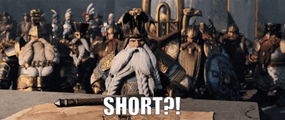 A Man With A Beard Is Sitting At A Table With The Words Short Written On The Table GIF