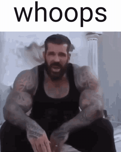 A Man With A Beard Is Sitting Down With The Words Whoops Above Him GIF