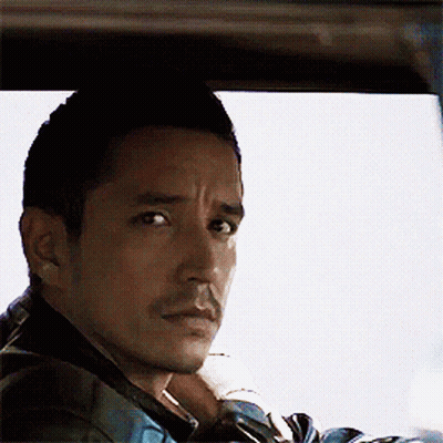 A Man With A Beard Is Sitting In A Car And Looking Out The Window GIF