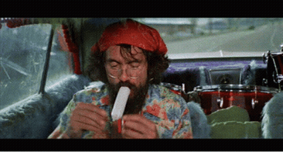 A Man With A Beard Is Sitting In A Car Eating A Popsicle GIF