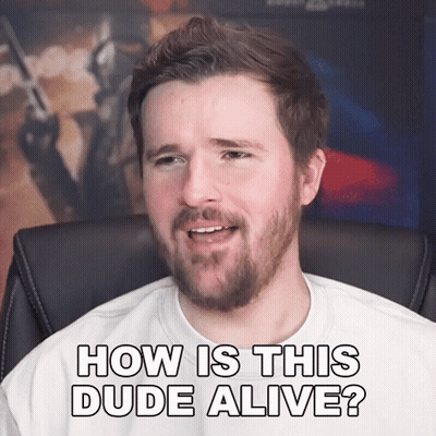 A Man With A Beard Is Sitting In A Chair And Says How Is This Dude Alive GIF