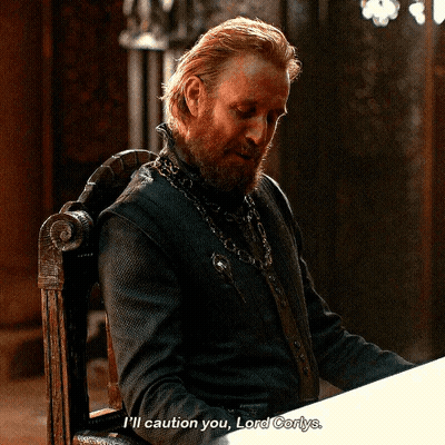 A Man With A Beard Is Sitting In A Chair And Says " I 'Ll Caution You Lord Corlys " GIF