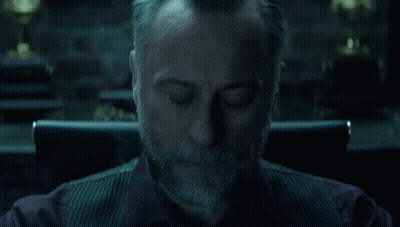 A Man With A Beard Is Sitting In A Chair With Smoke Coming Out Of His Mouth . GIF