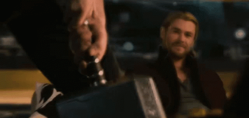 A Man With A Beard Is Sitting In A Dark Room GIF