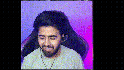 A Man With A Beard Is Sitting In A Gaming Chair With Headphones On . GIF