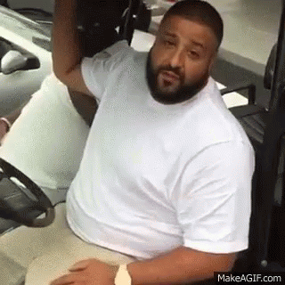 A Man With A Beard Is Sitting In A Golf Cart With His Hand On His Head . GIF