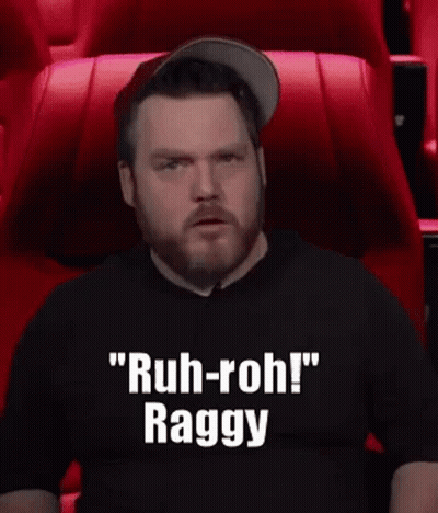 A Man With A Beard Is Sitting In A Theater Watching A Movie And Making A Funny Face . GIF