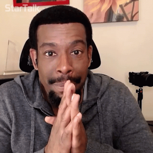 A Man With A Beard Is Sitting In Front Of A Camera With The Word Star Talk Written On The Wall Behind Him GIF
