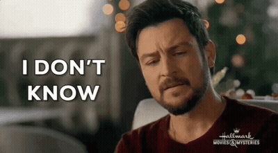 A Man With A Beard Is Sitting In Front Of A Christmas Tree And Saying `` I Don 'T Know '' . GIF
