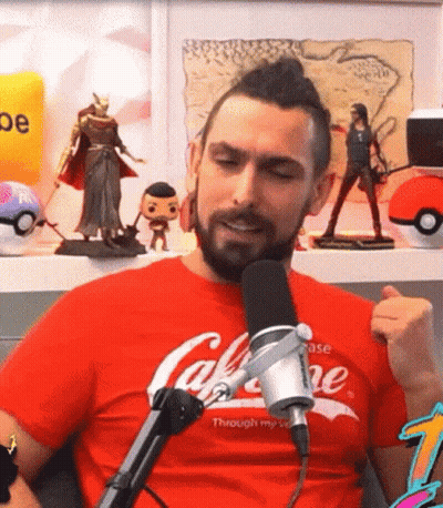A Man With A Beard Is Sitting In Front Of A Microphone Wearing A Red T-Shirt That Says Coca-Cola GIF