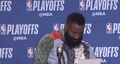 A Man With A Beard Is Sitting In Front Of A Microphone While Using A Laptop . GIF