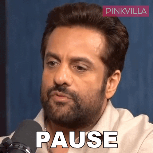 A Man With A Beard Is Sitting In Front Of A Microphone With The Word Pause Written On His Face GIF