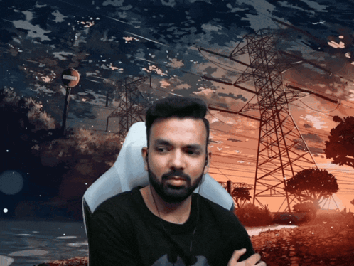 A Man With A Beard Is Sitting In Front Of A Sunset With Power Lines In The Background GIF