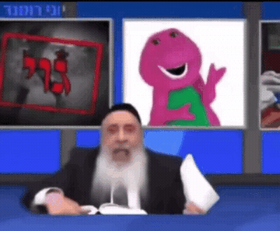 A Man With A Beard Is Sitting In Front Of A Television With A Picture Of Barney On The Screen . GIF