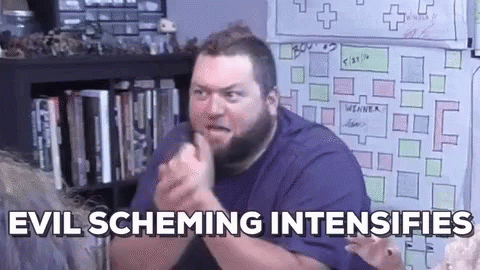 A Man With A Beard Is Sitting In Front Of A White Board And Making A Funny Face . GIF