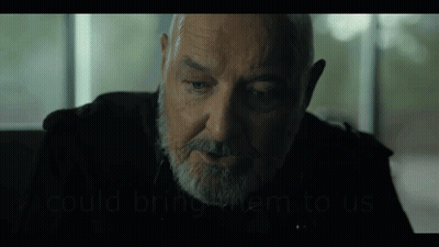 A Man With A Beard Is Sitting In Front Of A Window And Talking To Someone . GIF