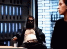 A Man With A Beard Is Sitting In Front Of A Window GIF