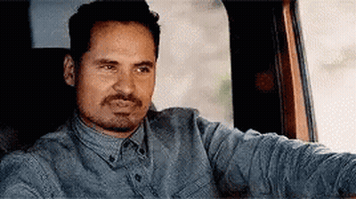 A Man With A Beard Is Sitting In The Back Seat Of A Car . GIF