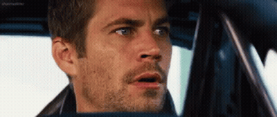 A Man With A Beard Is Sitting In The Driver 'S Seat Of A Car . GIF