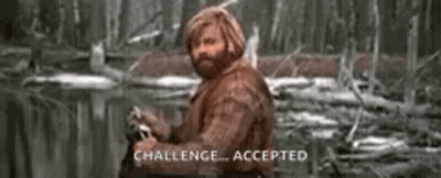 A Man With A Beard Is Sitting In The Woods Holding A Fishing Rod . GIF