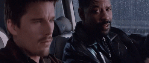 A Man With A Beard Is Sitting Next To Another Man In A Car . GIF
