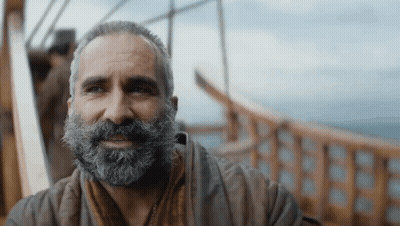 A Man With A Beard Is Sitting On A Boat GIF