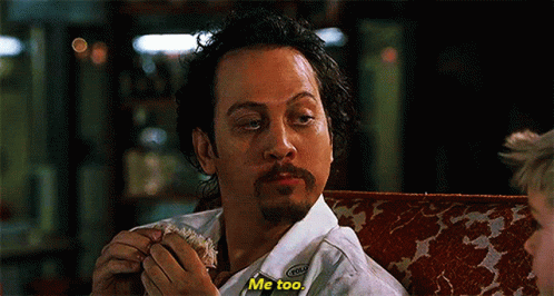 A Man With A Beard Is Sitting On A Couch Eating A Sandwich And Saying Me Too GIF