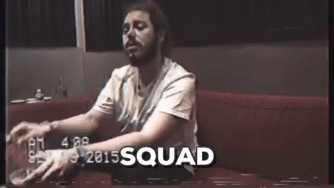 A Man With A Beard Is Sitting On A Couch With A Glass Of Beer In His Hand . GIF